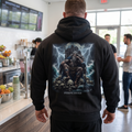 Apocalypse Gym Wear Njord god of the sea heavyweight black hoodie worn by a bodybuilder in a gym. Back view showing large Norse mythology warrior king seated on a throne of skulls with lightning and ocean waves.