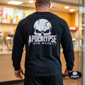 Apocalypse Gym Wear black long sleeve gym shirt worn by a bodybuilder. Back view showing a high-contrast white cracked skull logo and dripping block typography print.