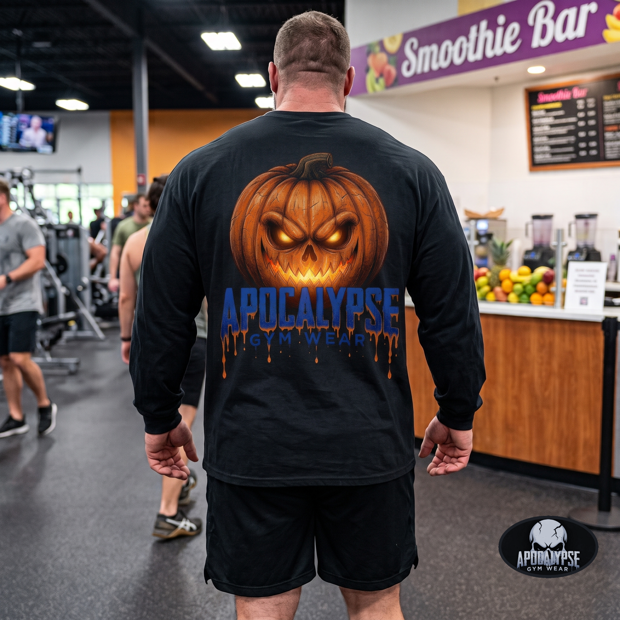 Apocalypse Gym Wear orange pumpkin skull long sleeve black shirt worn by a bodybuilder in a gym. Back view showing a massive glowing jack-o'-lantern back print above blue dripping typography.
