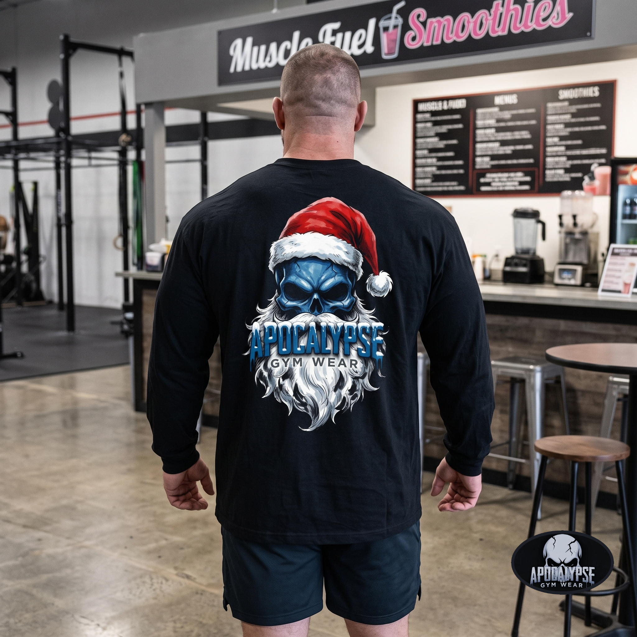 Apocalypse Gym Wear frozen Santa skull long sleeve black gym shirt worn by a bodybuilder. Back view showing an icy blue skull graphic with red Santa hat and frosted dripping typography.