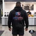 Apocalypse Gym Wear patriotic American flag skull heavyweight black hoodie worn by a bodybuilder in a gym. Back view showing large distressed skull graphic with integrated US flag and 3D textured typography.