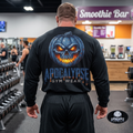 Apocalypse Gym Wear blue pumpkin skull long sleeve black shirt front view worn by a bodybuilder in a gym, featuring a small left chest jack-o'-lantern print.