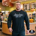 Apocalypse Gym Wear front logo black long sleeve gym shirt worn by a bodybuilder. Front view showing dark grey splatter brush brand typography print across the chest.